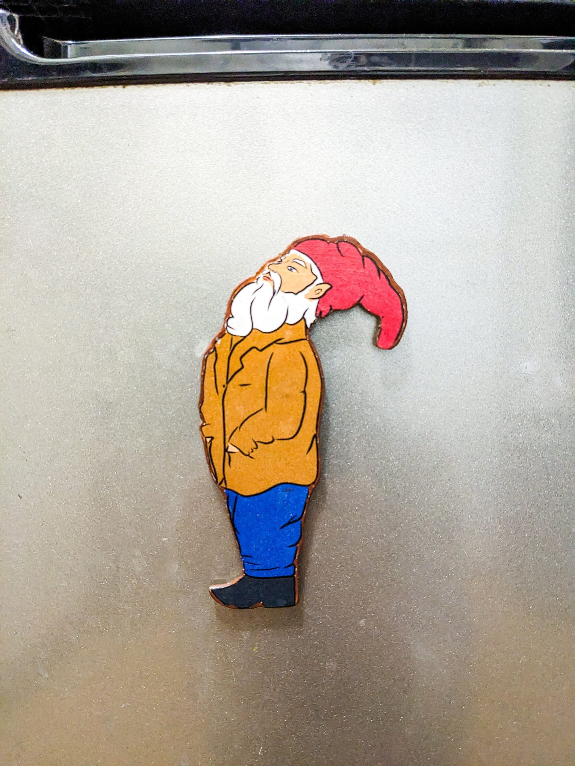 Close detail of wood grain on handcrafted gnome refrigerator magnet — natural materials home decor.