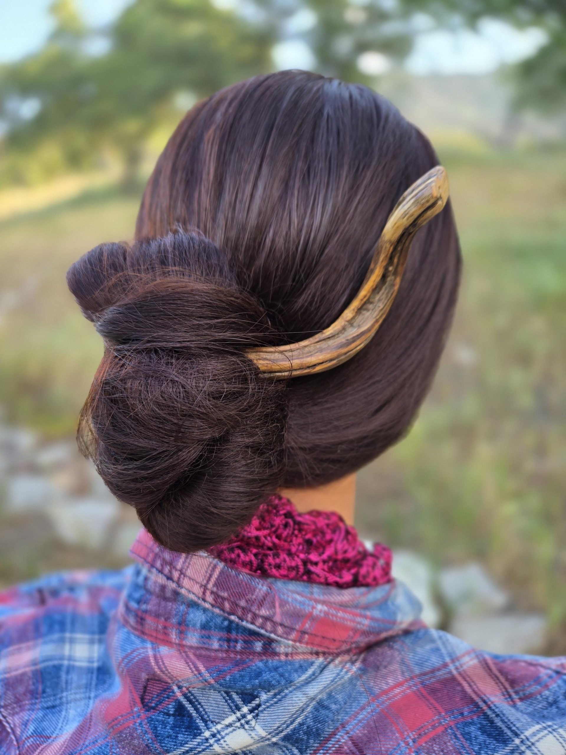 Natural twisted wood hair fork on rustic stone — artisan hair holder made from windfall wood.